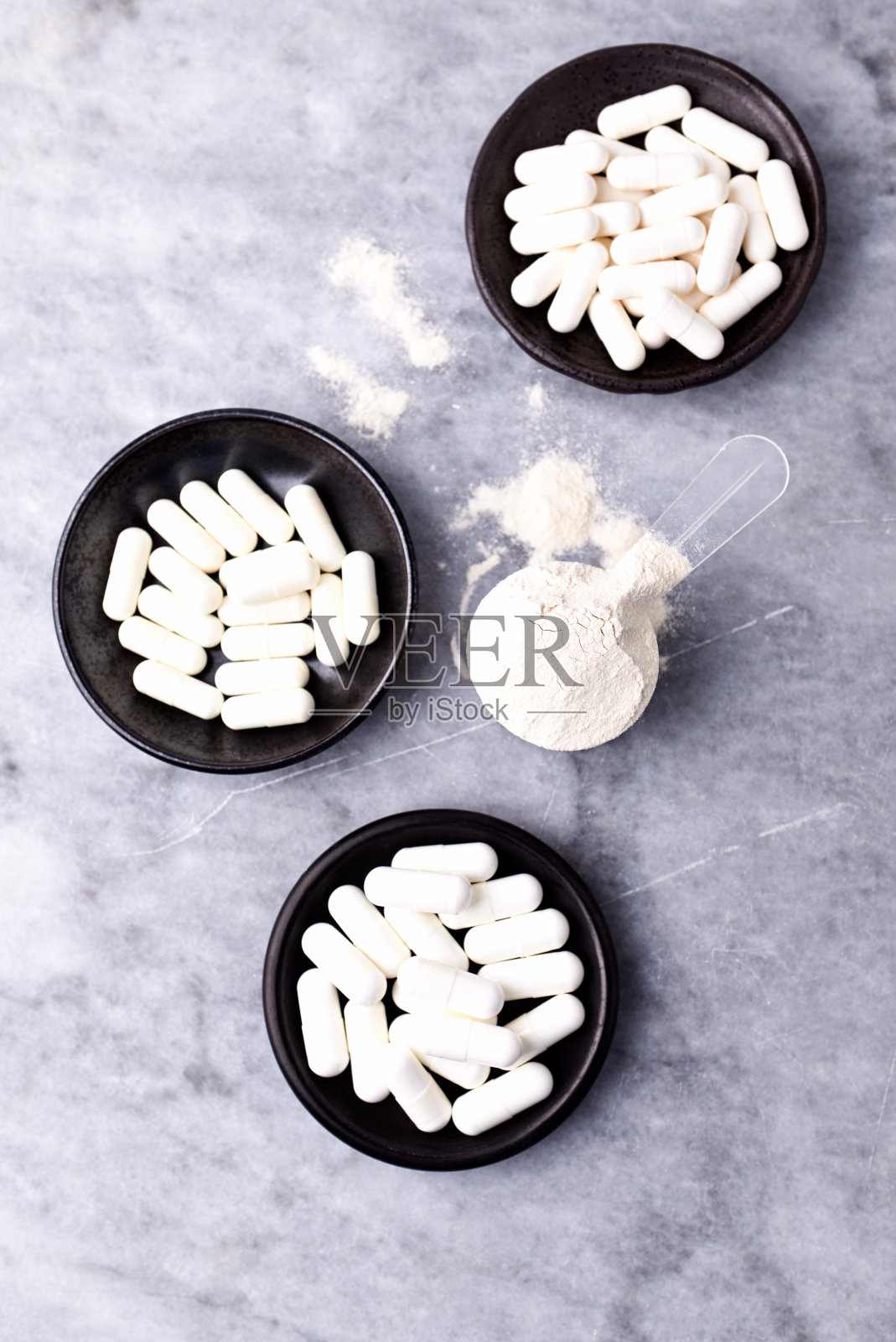 乳清蛋白,水解膠原I型,l -脯氨酸和l -賴氨酸膠囊勺。補充膠原蛋白的生產(chǎn)。明亮的石頭背景。直接上圖。副本的空間。